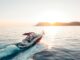 man riding on white and red boat on sea during daytime