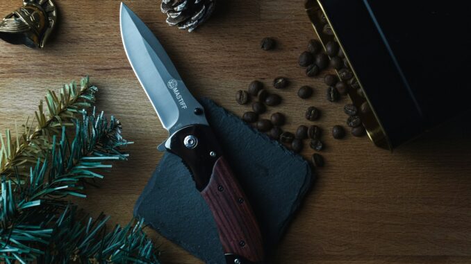 brown and silver folding knife on brown wooden table