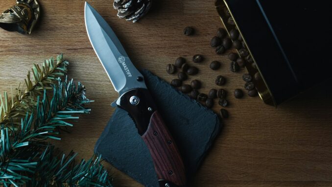 Photo by YearOne brown and silver folding knife on brown wooden table