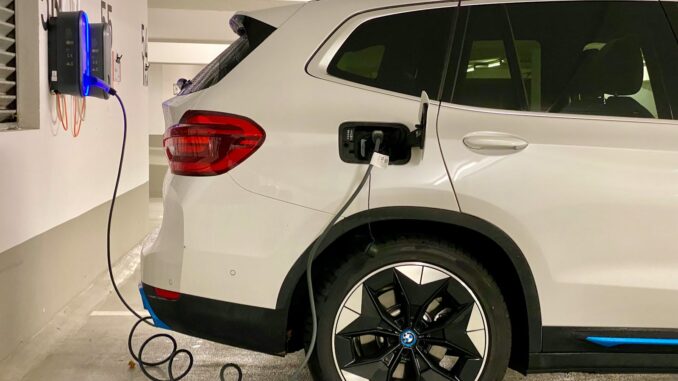 Photo by Eren Goldman an electric car plugged in to a charging station